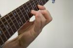 Någon fingerspelar på en gitarr.